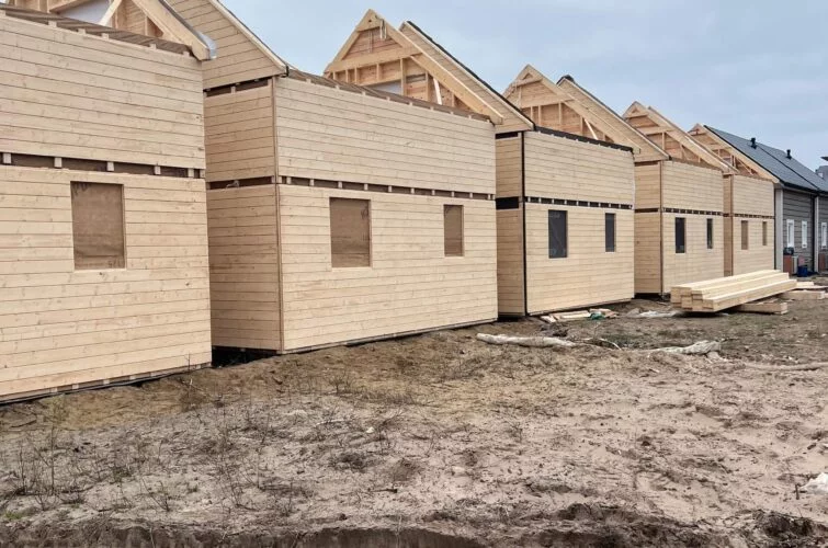 Szereg drewnianych konstrukcji domów modułowych na placu budowy